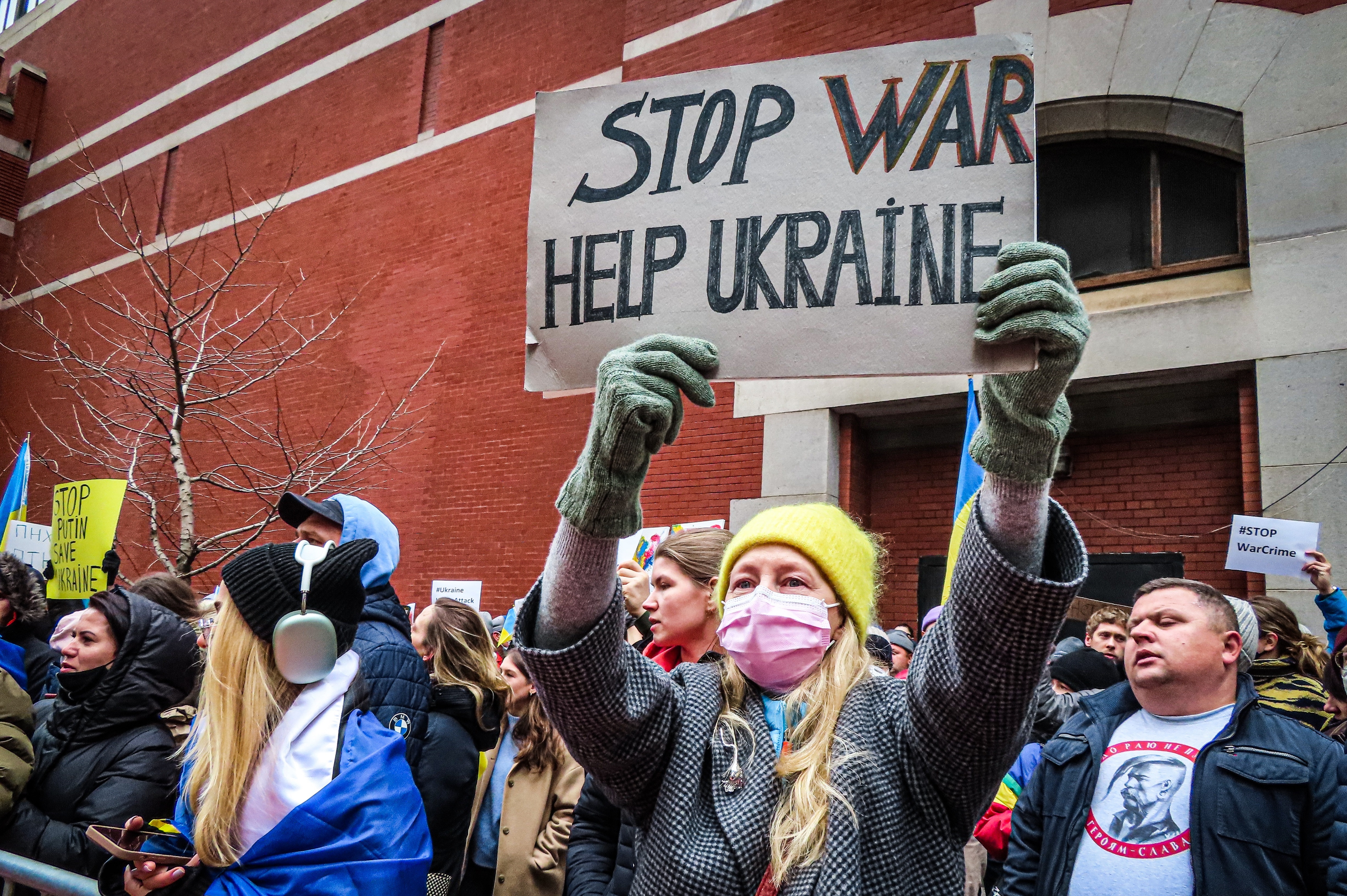 Woman is holding sign stop war help Ukraine